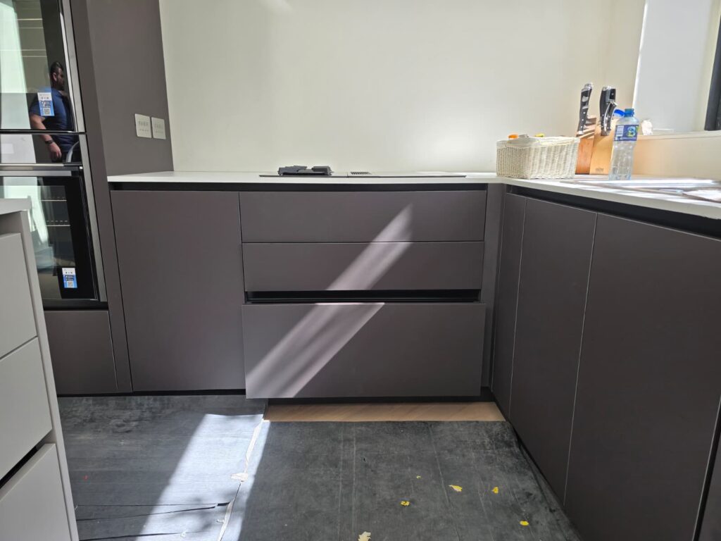 Handleless dark kitchen drawers during installation in Dublin 4