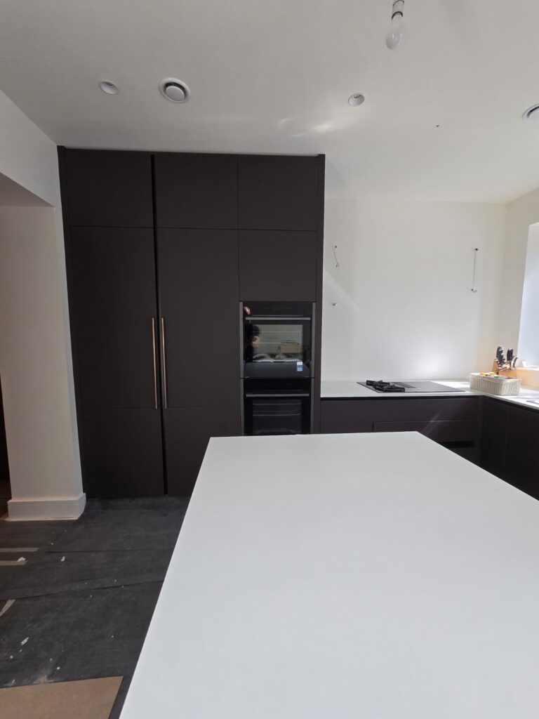 Dublin 4 kitchen during installation, with tall dark cabinetry and central island