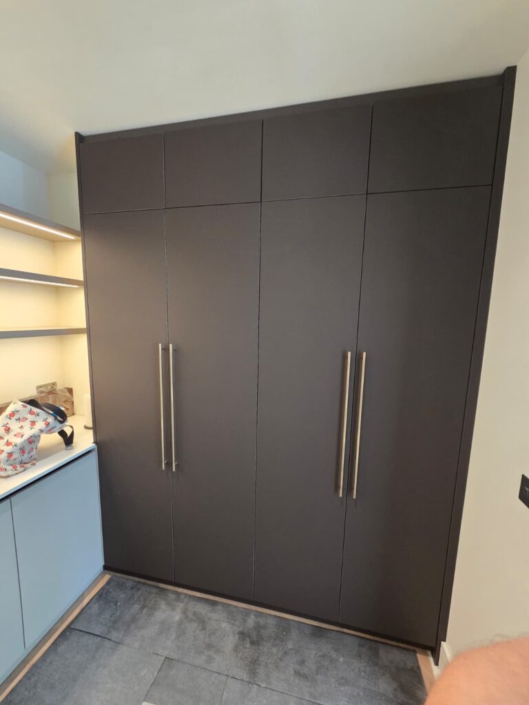 Full-height dark pantry cupboards with long handles